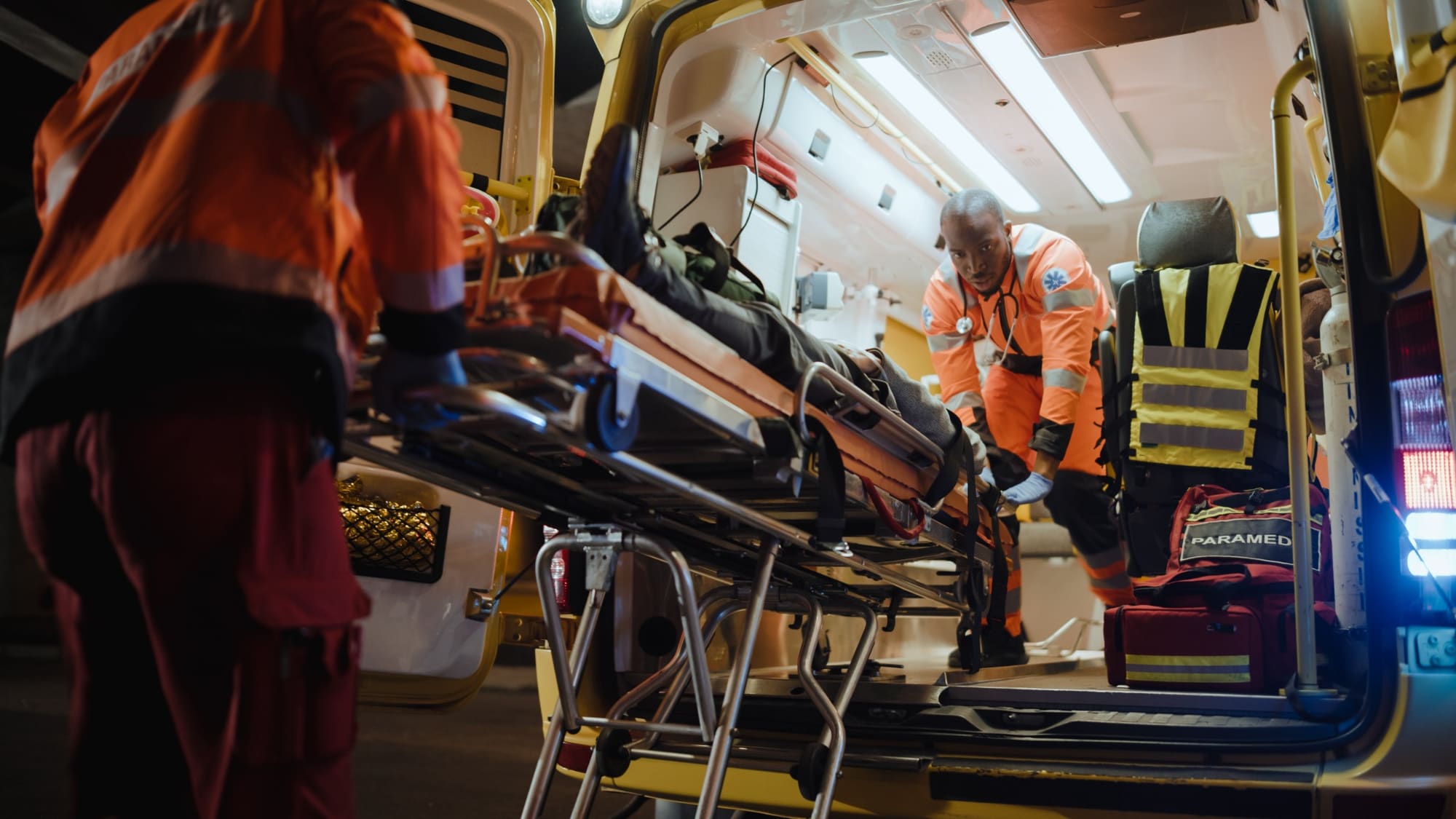 Emergency medical professionals assisting a patient at an ambulance